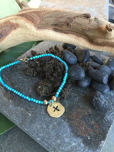 Turquoise bead bracelet with14 karat yelliw gold cross disc charm